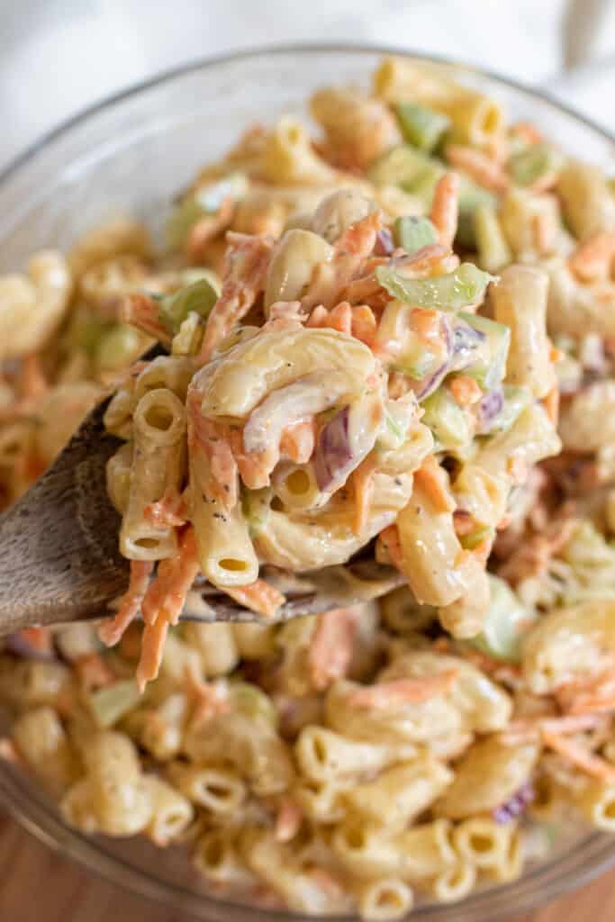 a large bowl of macaroni salad with a spoon.