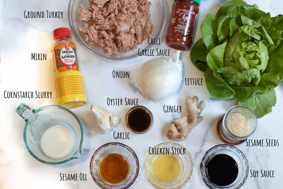 ground turkey, lettuce, mirin, cornstarch slurry, onion, ginger, garlic, sesame seeds, and small bowls of oyster sauce, soy, stock, sesame oil, and chili garlic sauce.