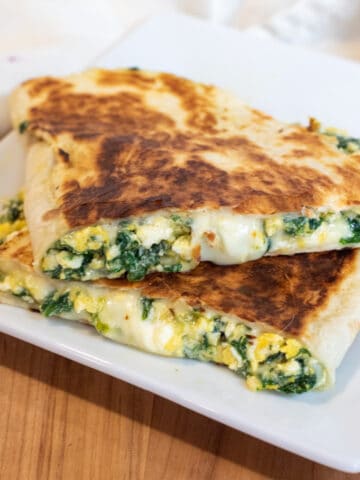 a quesadilla with spinach and cheese on a plate.