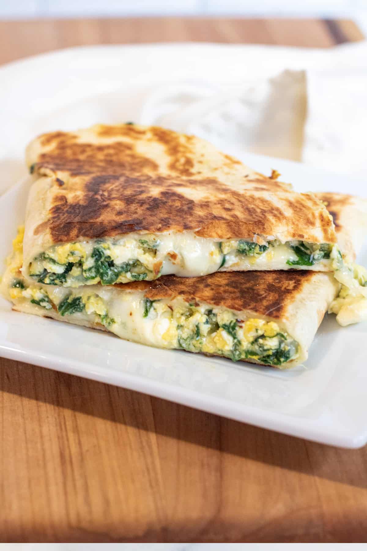 a quesadilla with spinach and cheese on a plate.