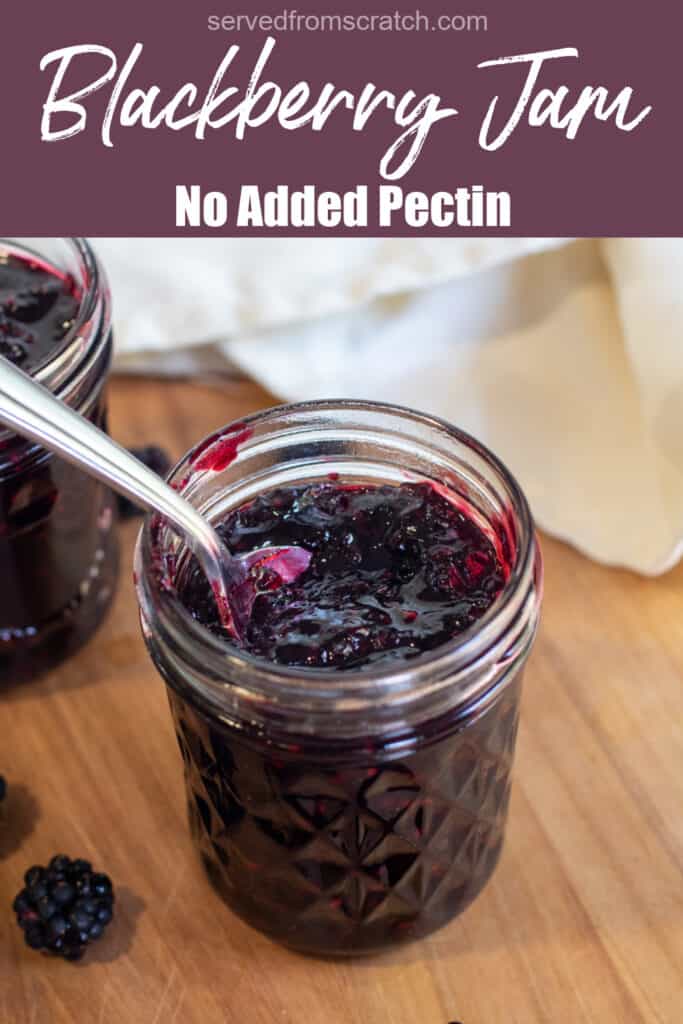 a jar of open blackberry jam with a spoon of jam with Pinterest pin text.