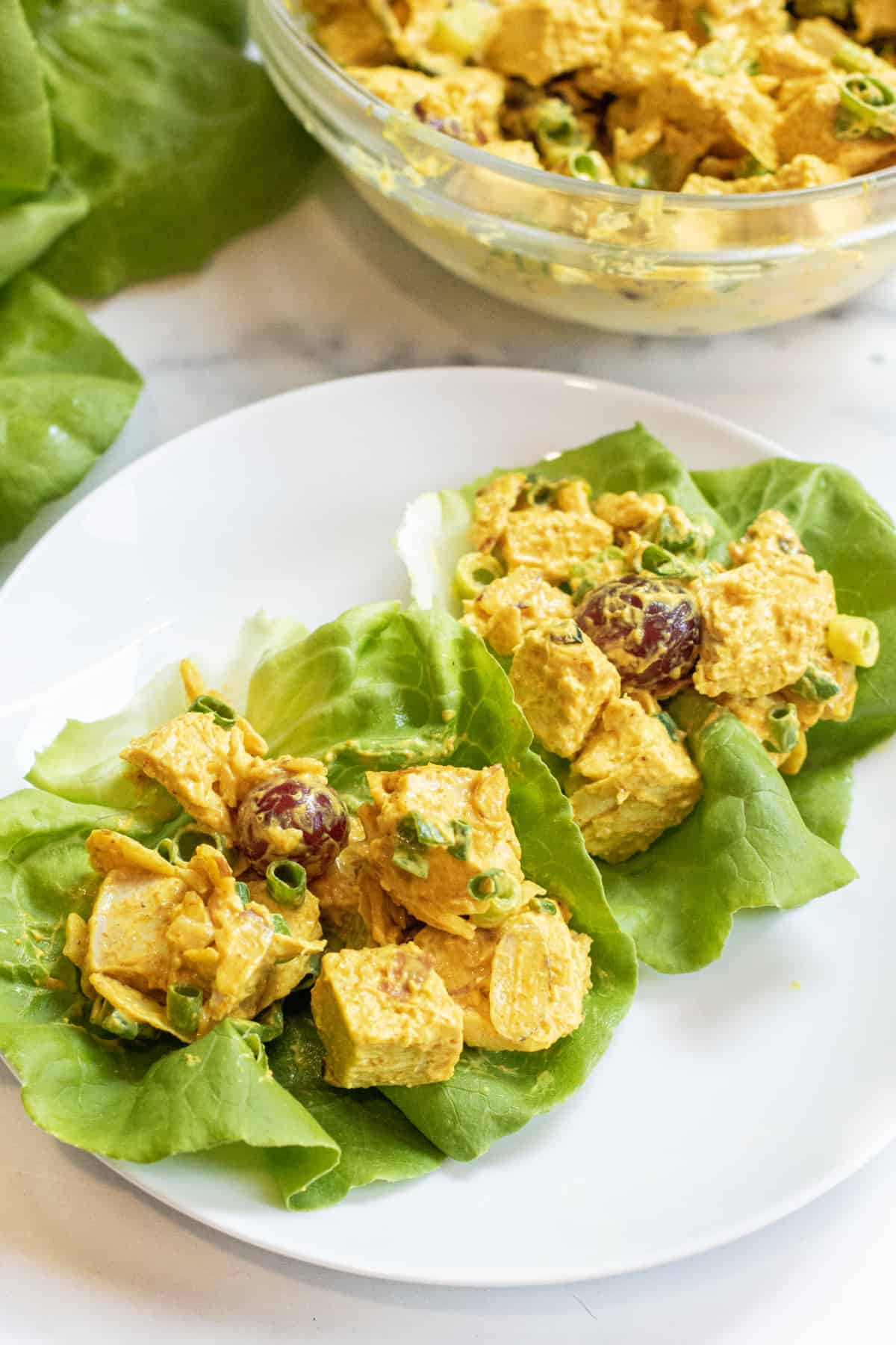 lettuce wraps with curry chicken salad on a plate.