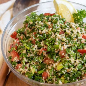 a bowl of tabbouleh with a lemon wedge.