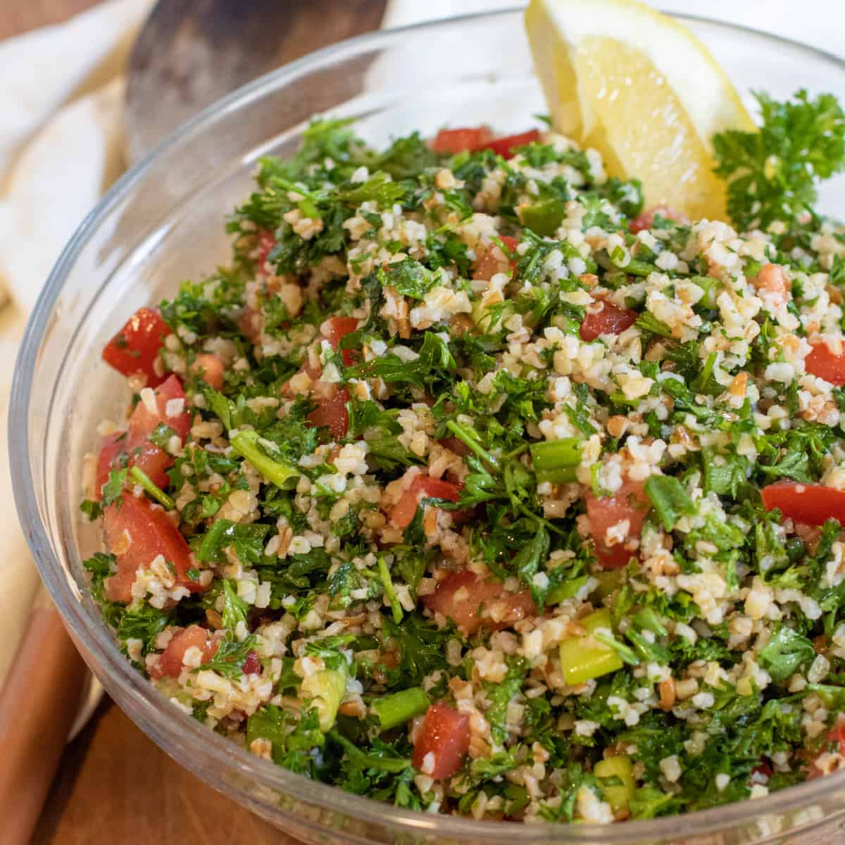 a bowl of tabbouleh with a lemon wedge. 