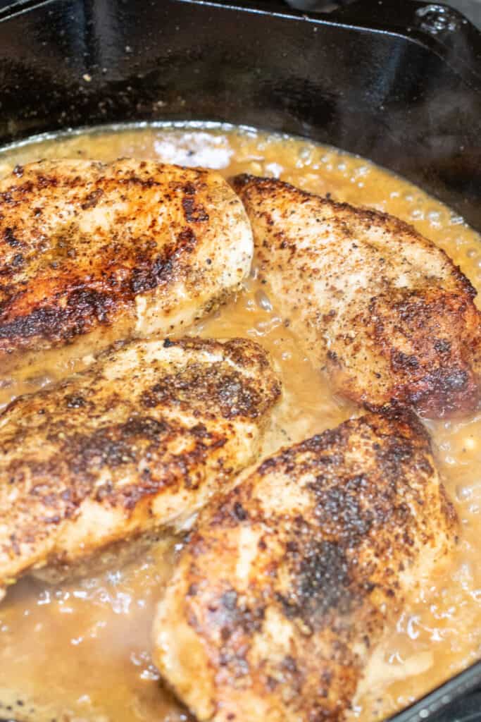 a cast iron of cooked chicken breasts.