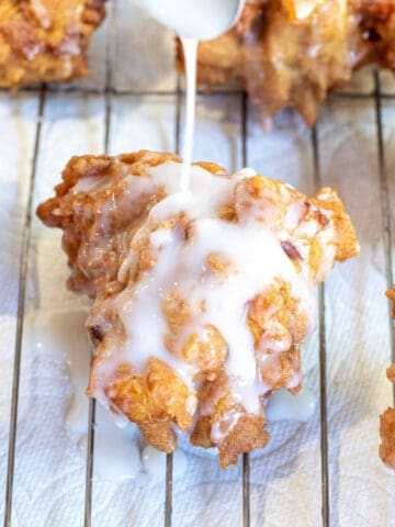 a spoon pouring glaze on a fritter.