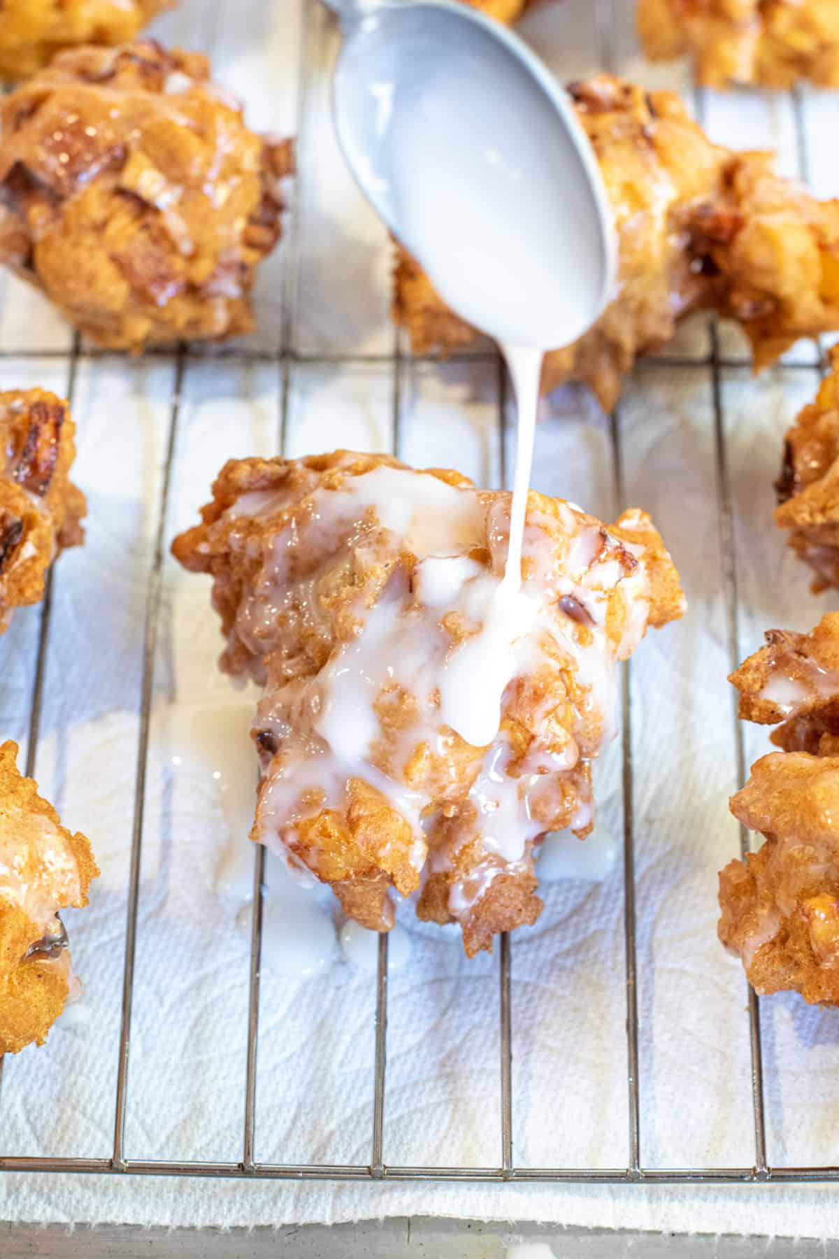 a spoon pouring glaze on a fritter.