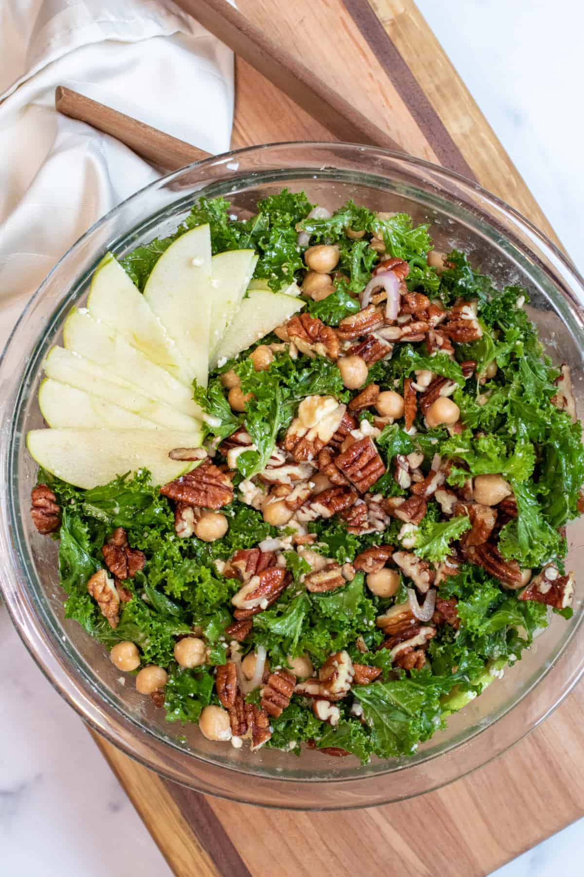 an overhead shot of a kale salad with apples, pecans, and chickpeas.