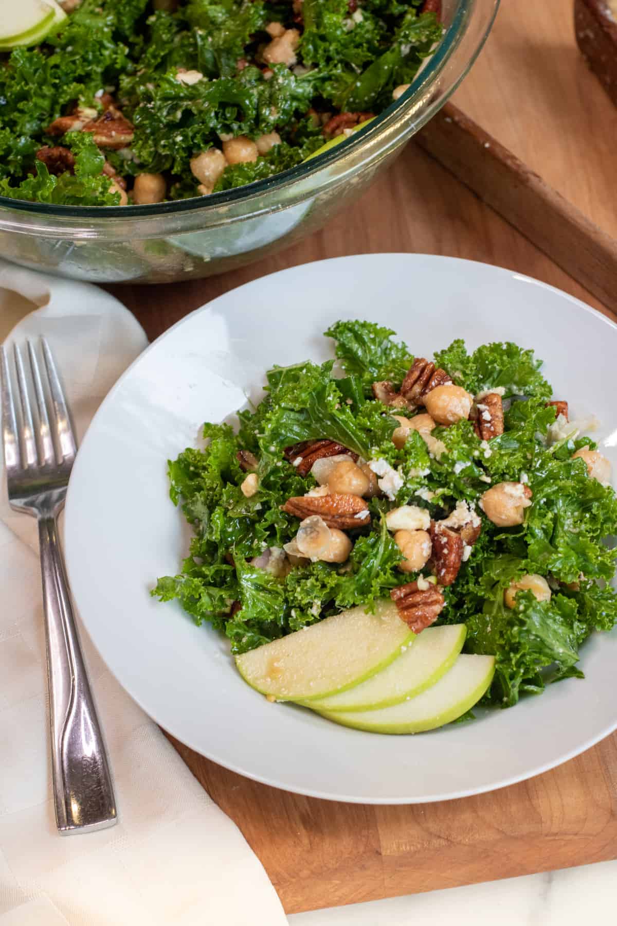 a bowl of kale salad with pecans, chickpeas, and feta.
