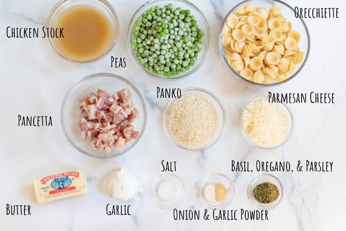 pasta, peas, pancetta, panko, parmesan, butter, spices on a counter.