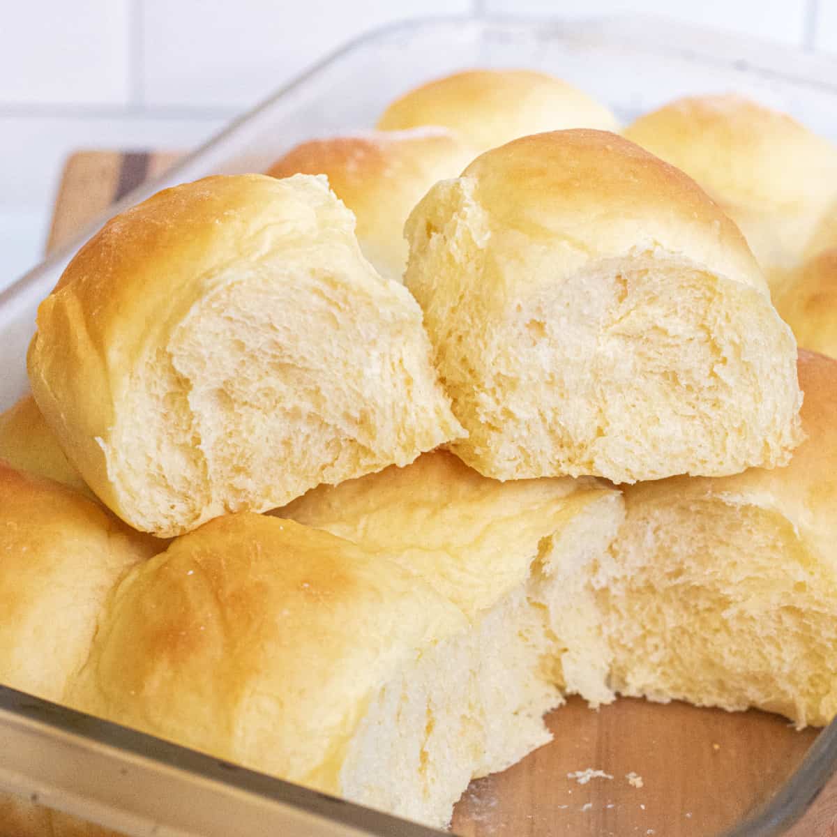 two rolls out of a pan of rolls sitting on the other rolls.