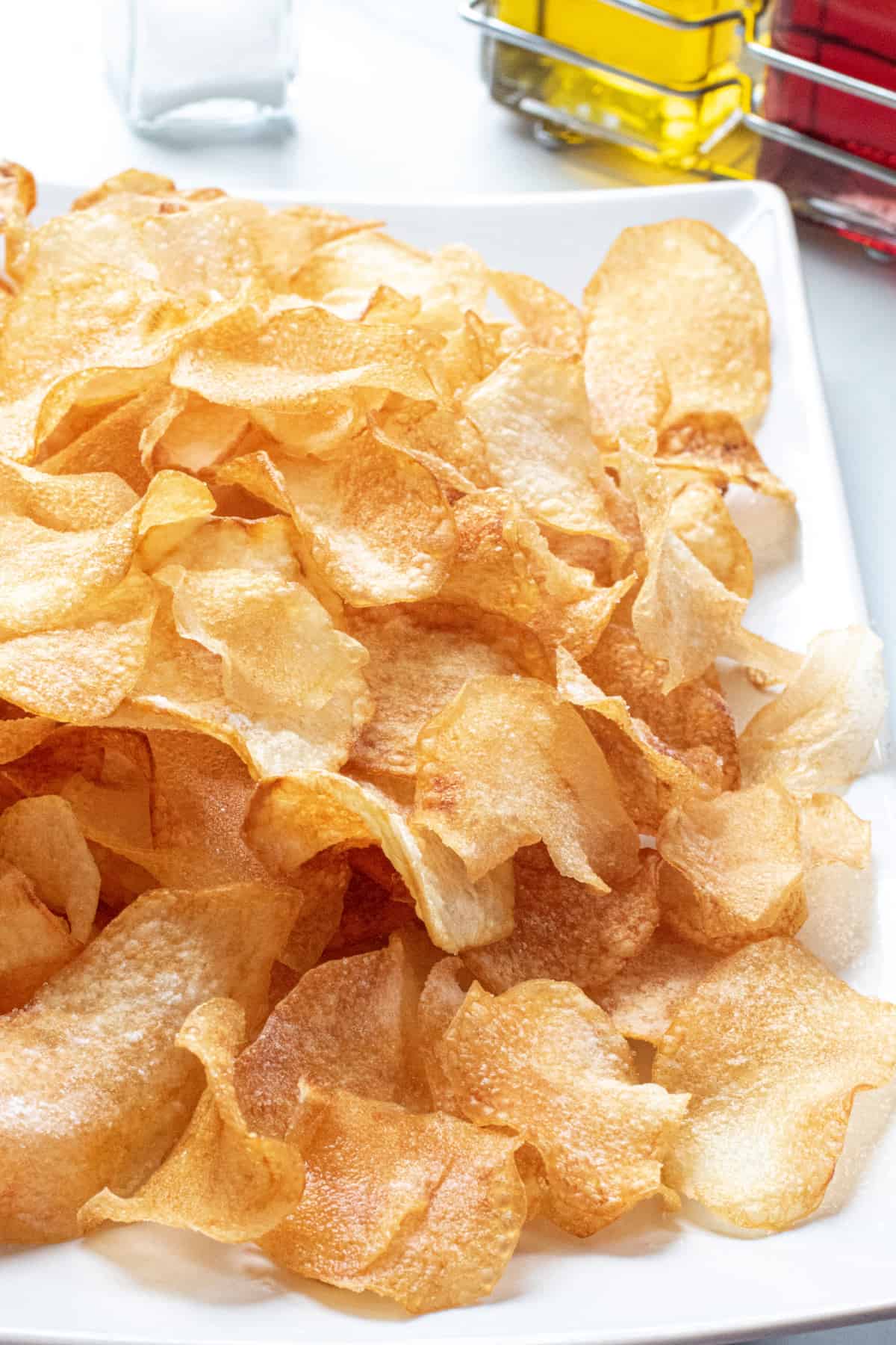a close up of a plate of crispy homemade potato chips.