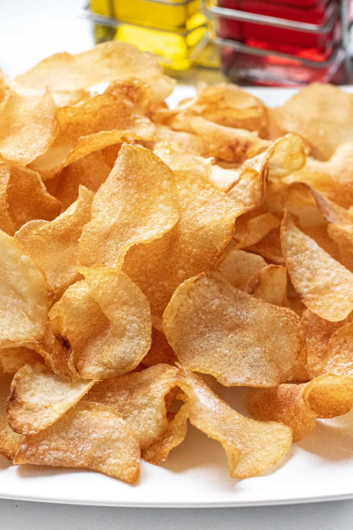 a close up of a plate of crispy homemade potato chips.