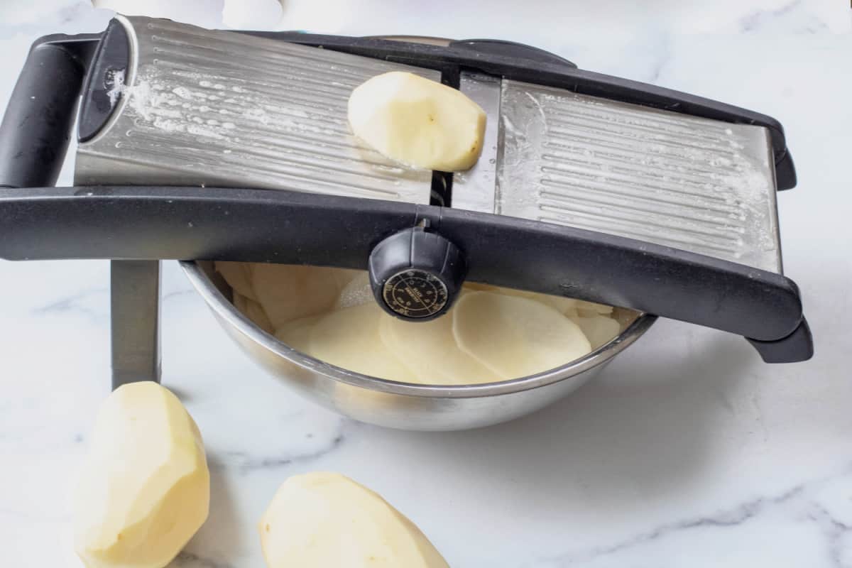 a mandolin slicing a potato.