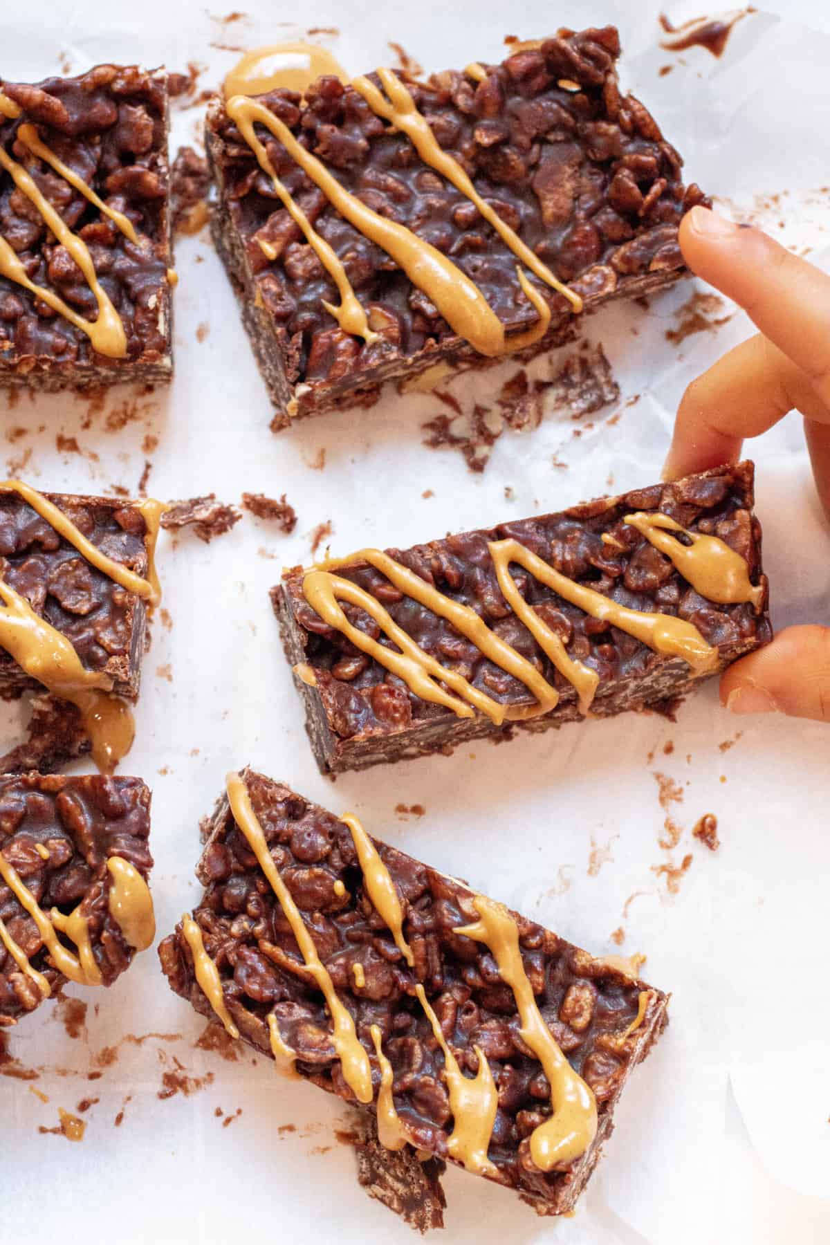 a little hand holding a peanut butter swirled chocolate bar.