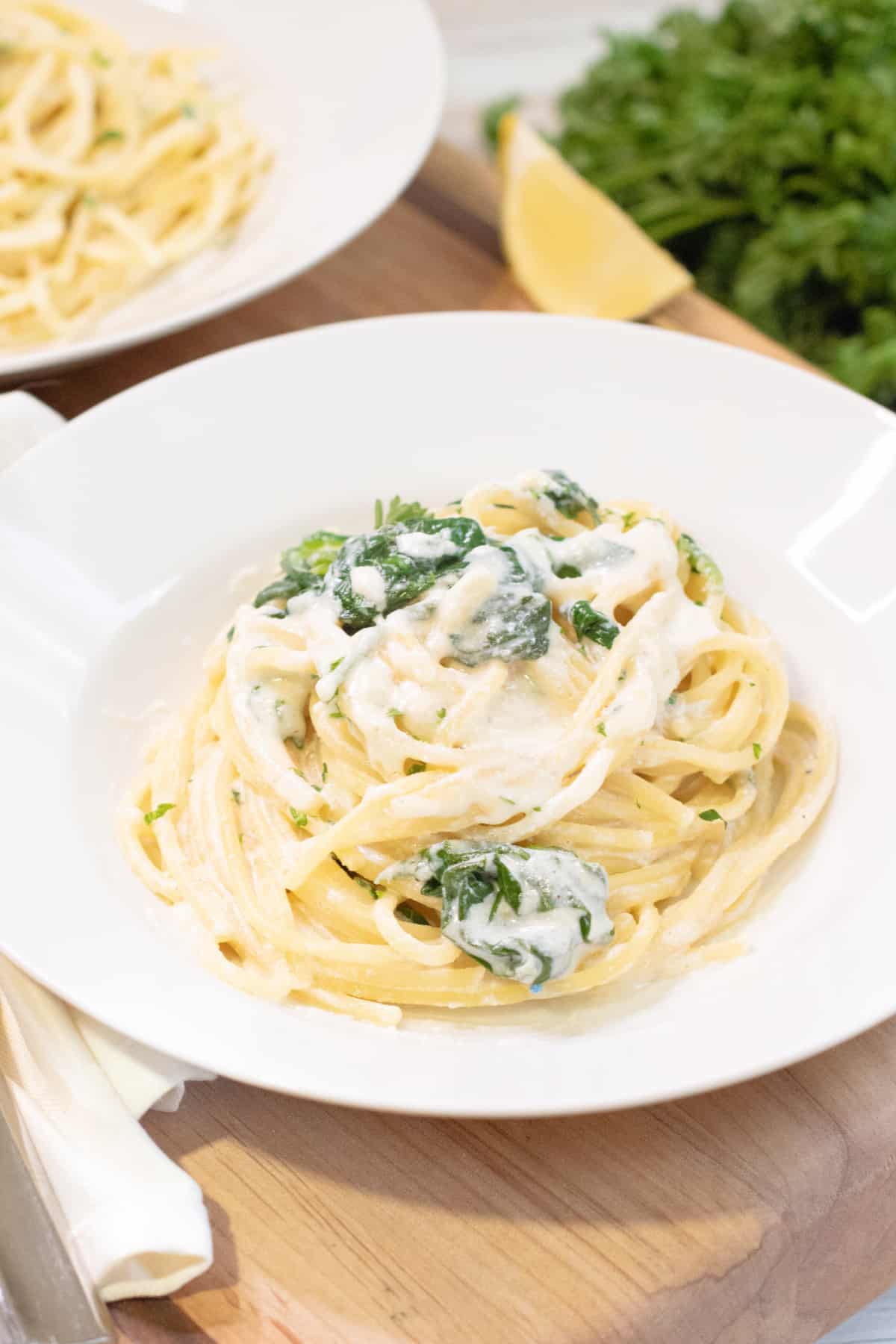 a plate with creamy pasta and spinach.