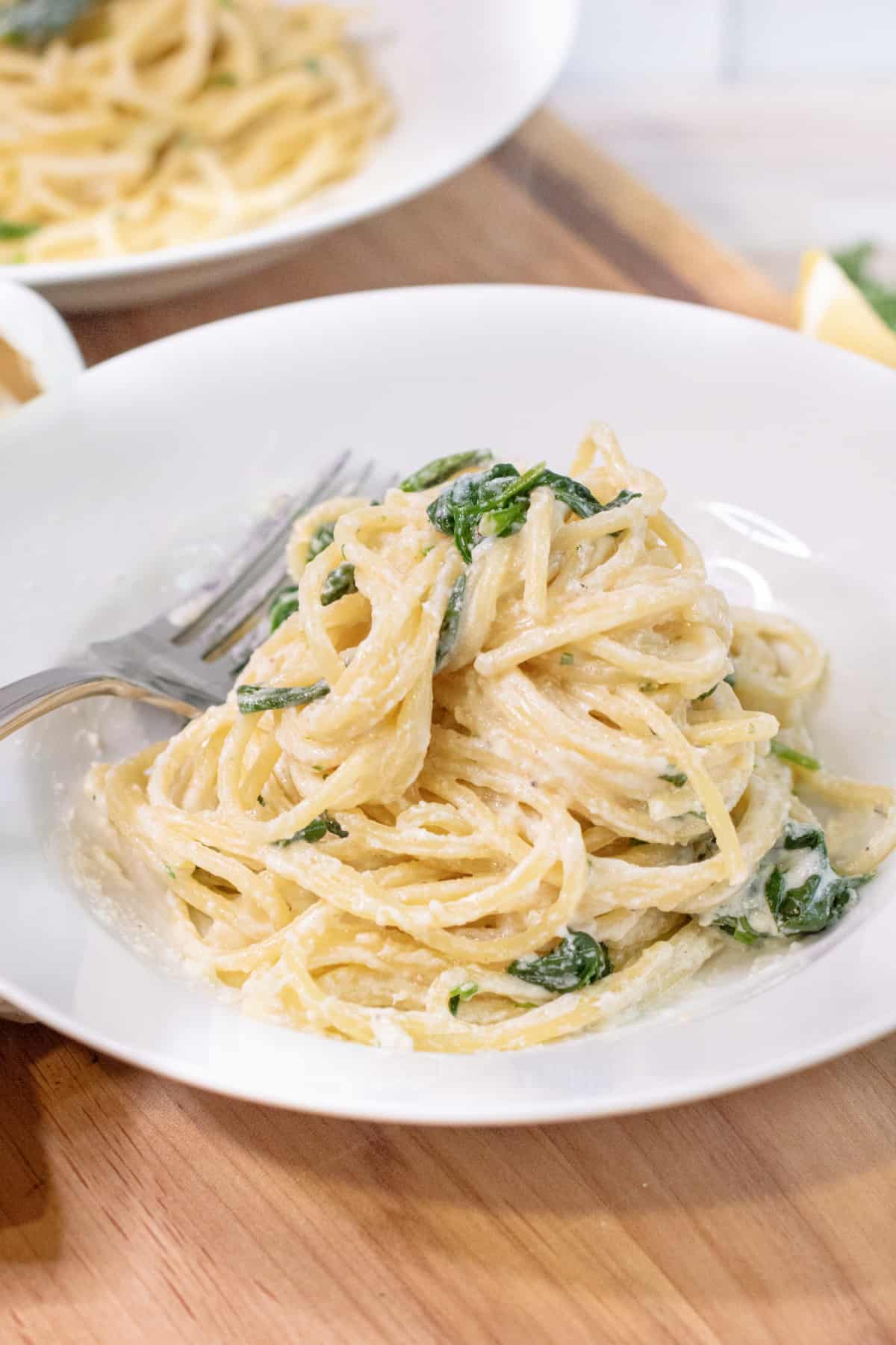 a plate with creamy pasta and spinach.