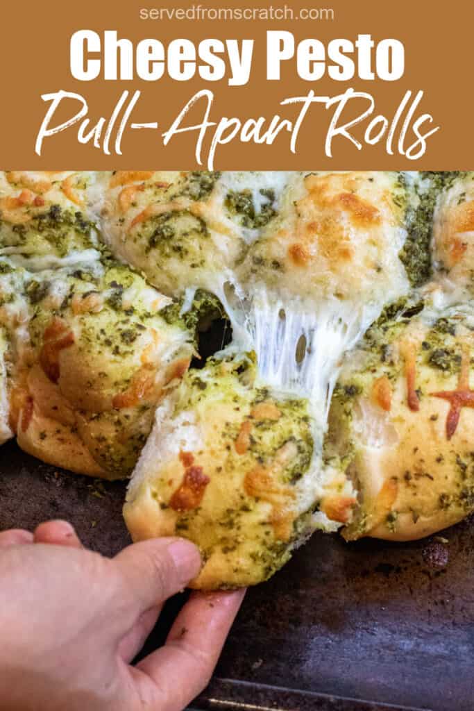 a hand pulling a cheesy pesto covered roll out from a bunch of rolls with Pinterest pin text.