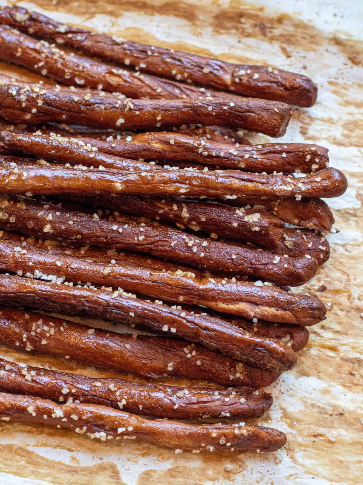 baked and salted pretzel rods on parchment paper.