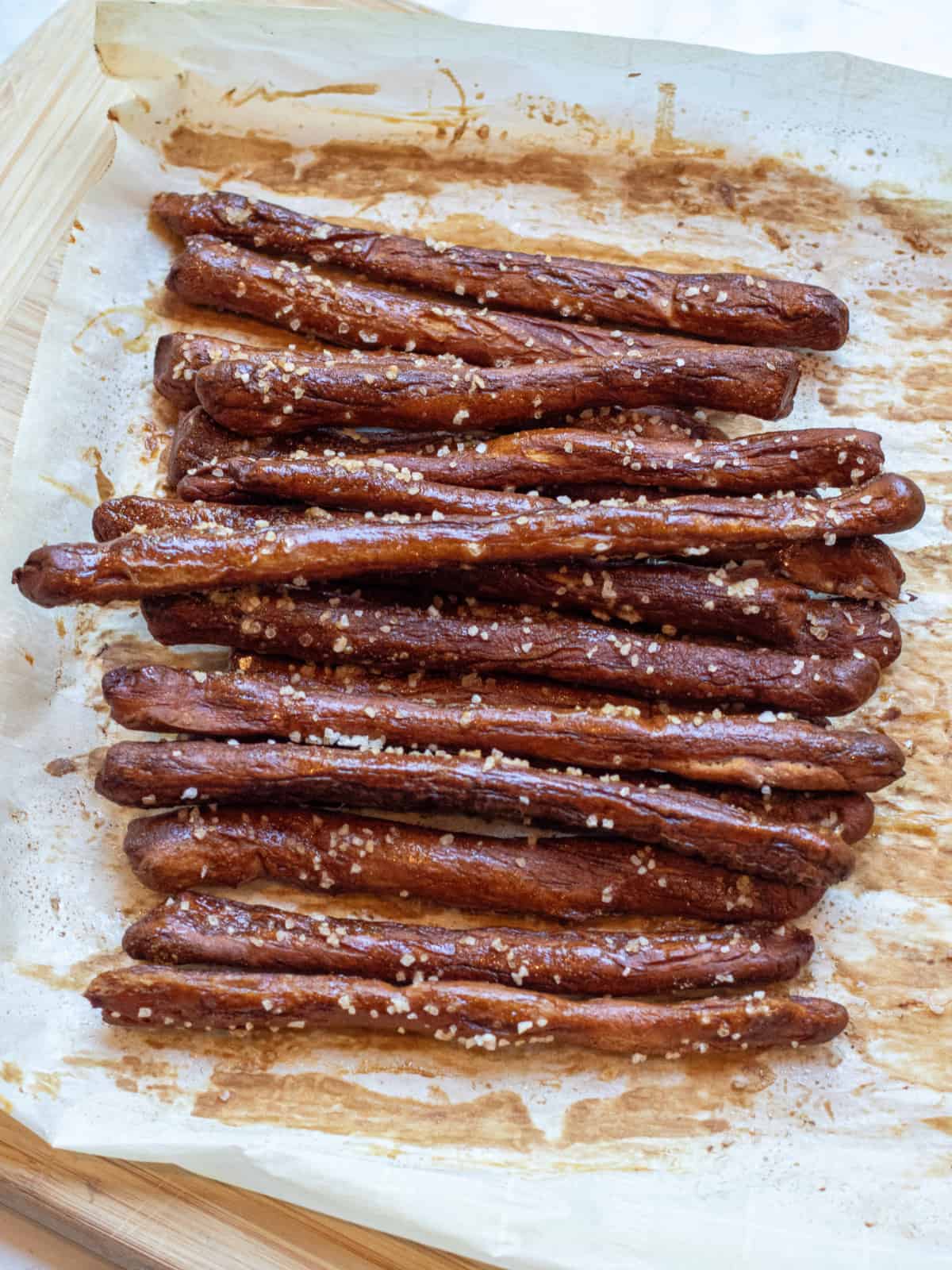 baked and salted pretzel rods on parchment paper.