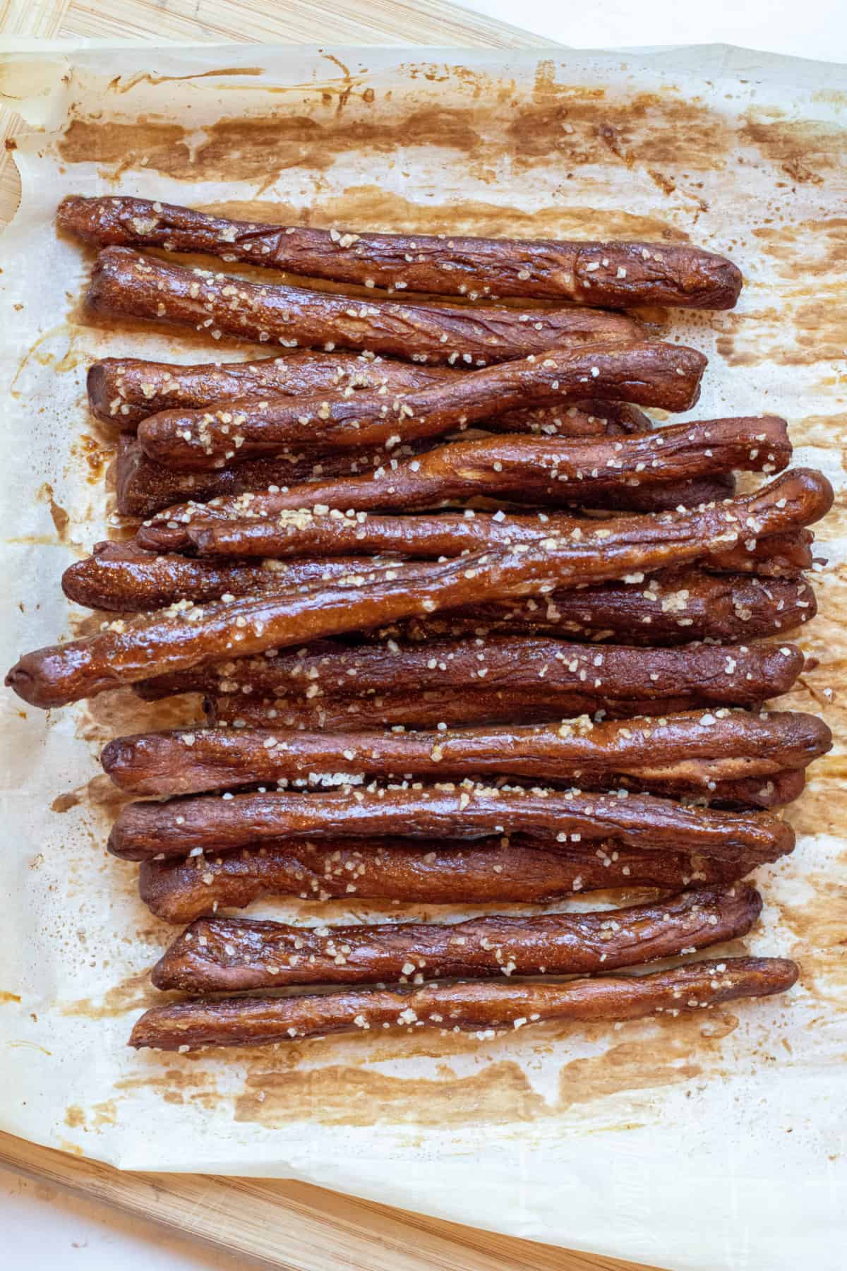 baked and salted pretzel rods on parchment paper.