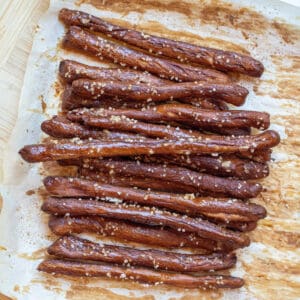 baked and salted pretzel rods on parchment paper.