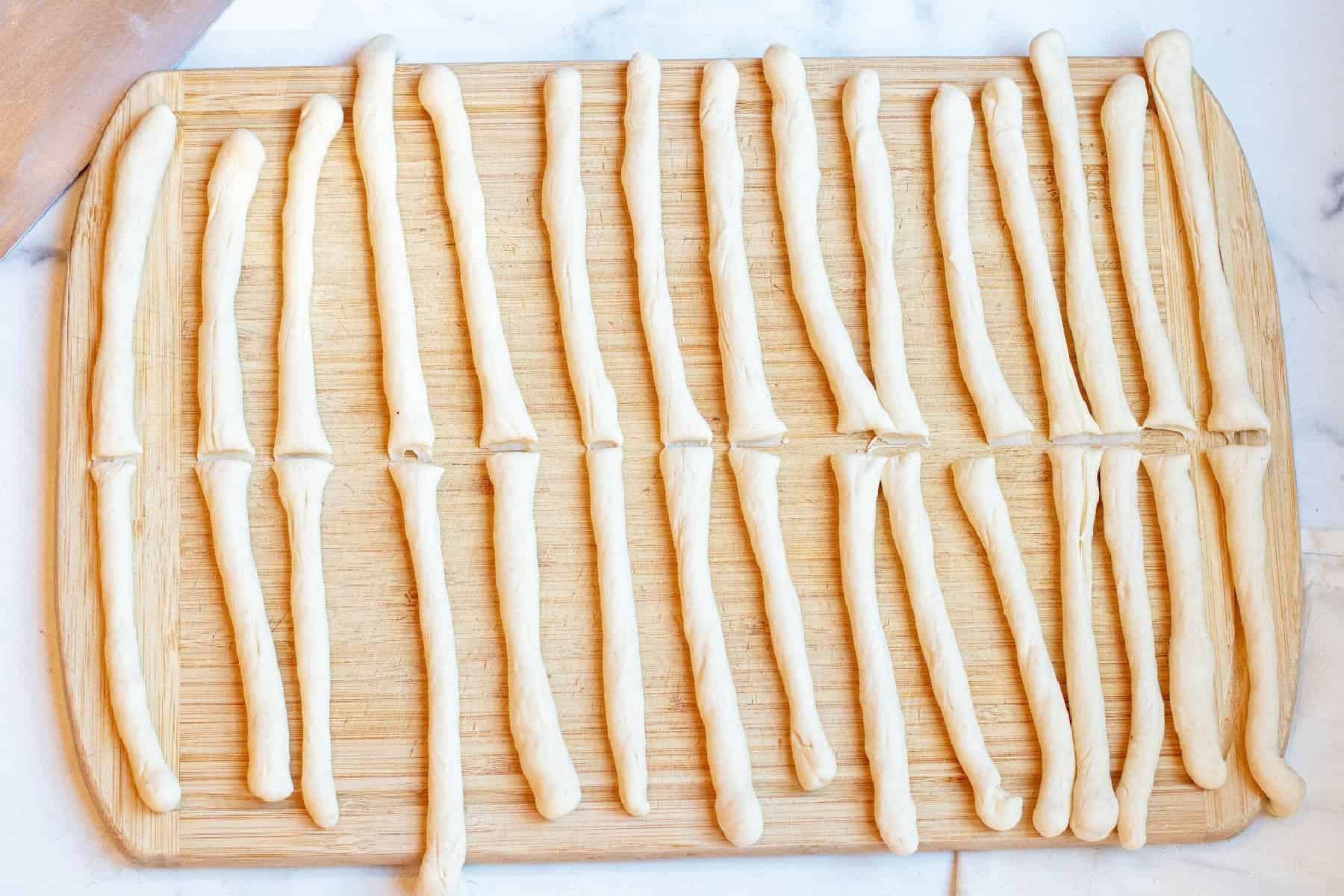 rolled out dough rods on a cutting board. 