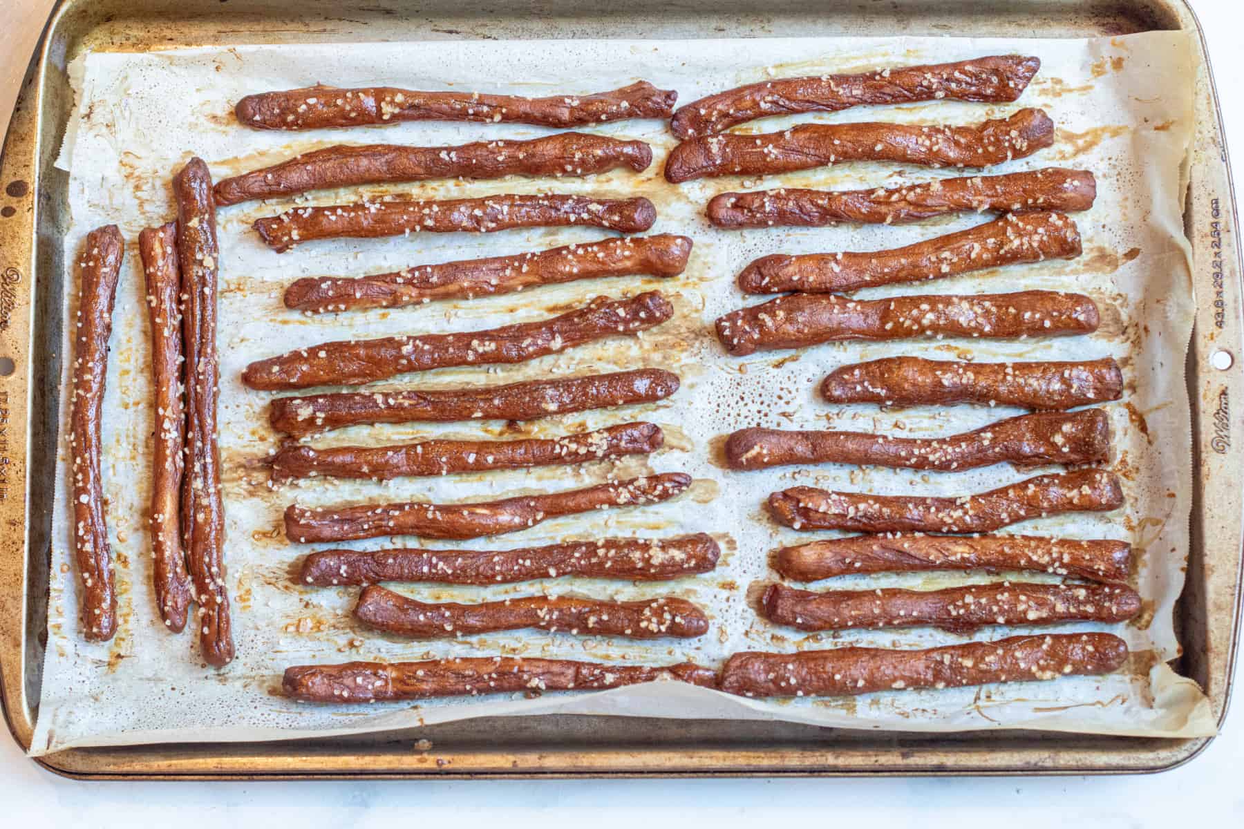 baked pretzel rods on a tray with parchment paper.