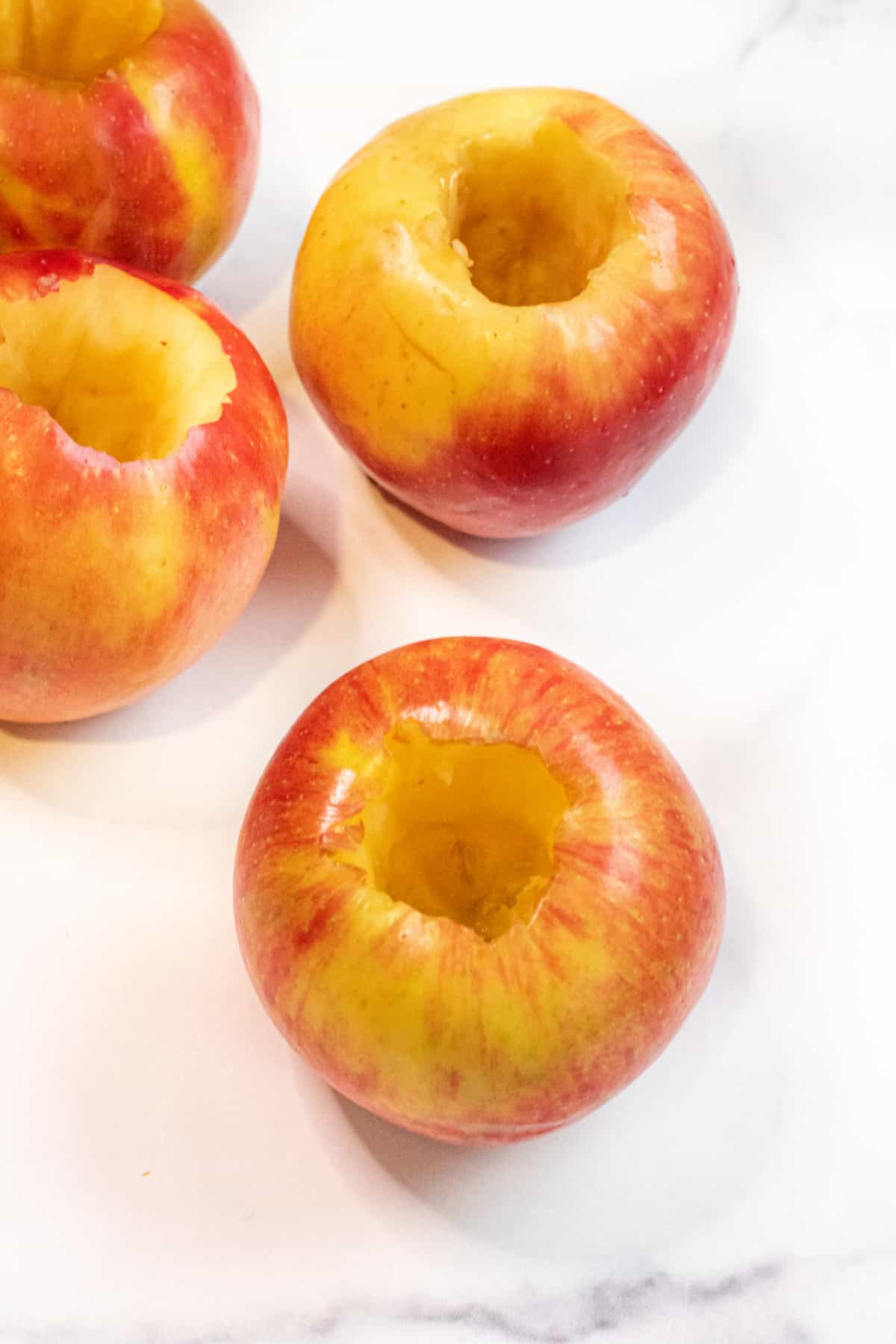 a cored apple in front of 3 other cored apples. 