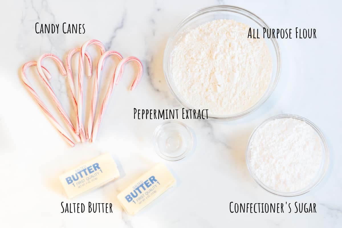 candy canes, a bowl of flour, sugar, two sticks of butter, and peppermint extract.