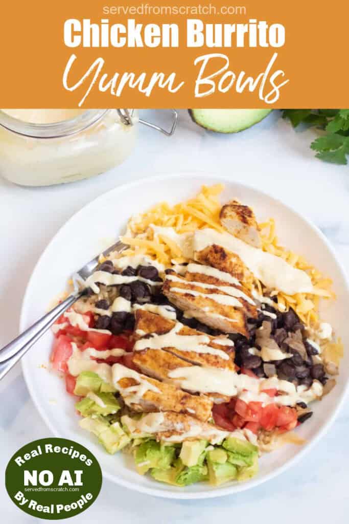 an overhead of a burrito bowl with chicken, avocado, tomatoes, rice, cheese, and sauce with Pinterest pin text and NO AI sticker.