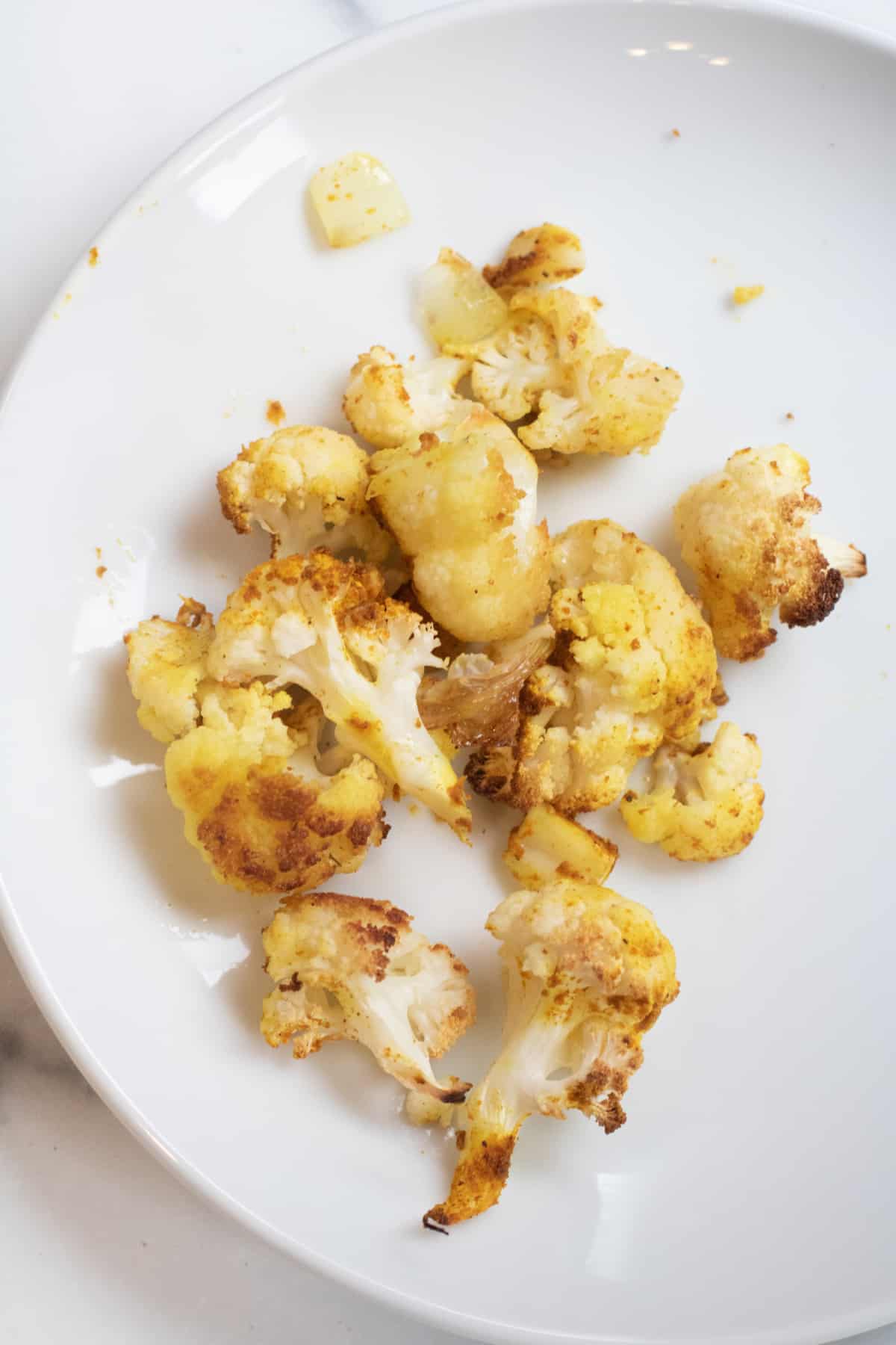 a plate of roasted pieces of cauliflower.