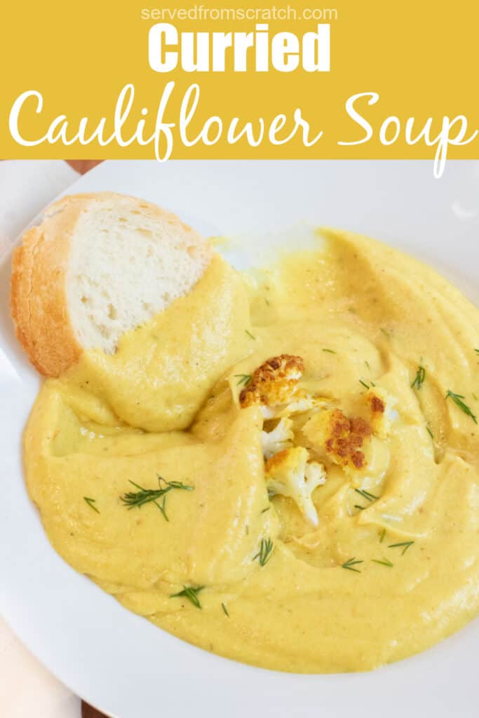 a bowl of creamy yellow soup with dill and cauliflower with a piece of baguette in it with Pinterest pin text.