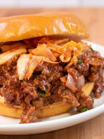 a close up of a sloppy joe with kimchi.