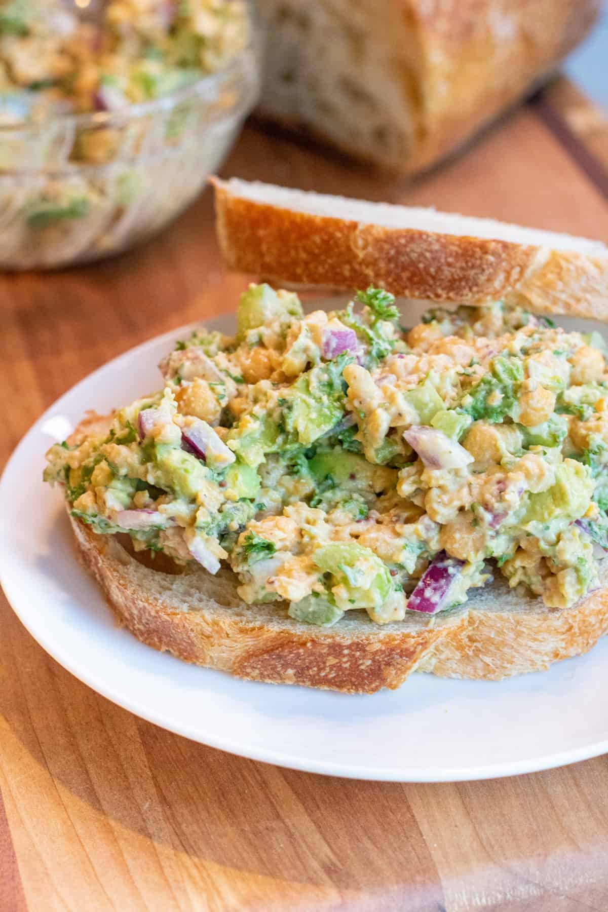 an open sandwich of chickpea avocado salad on a plate.