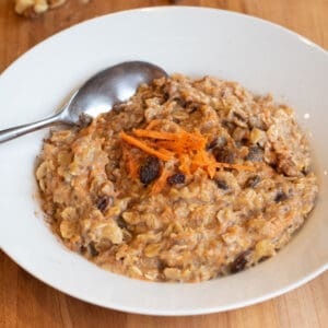 a bowl of carrot cake oatmeal with a spoon in it.