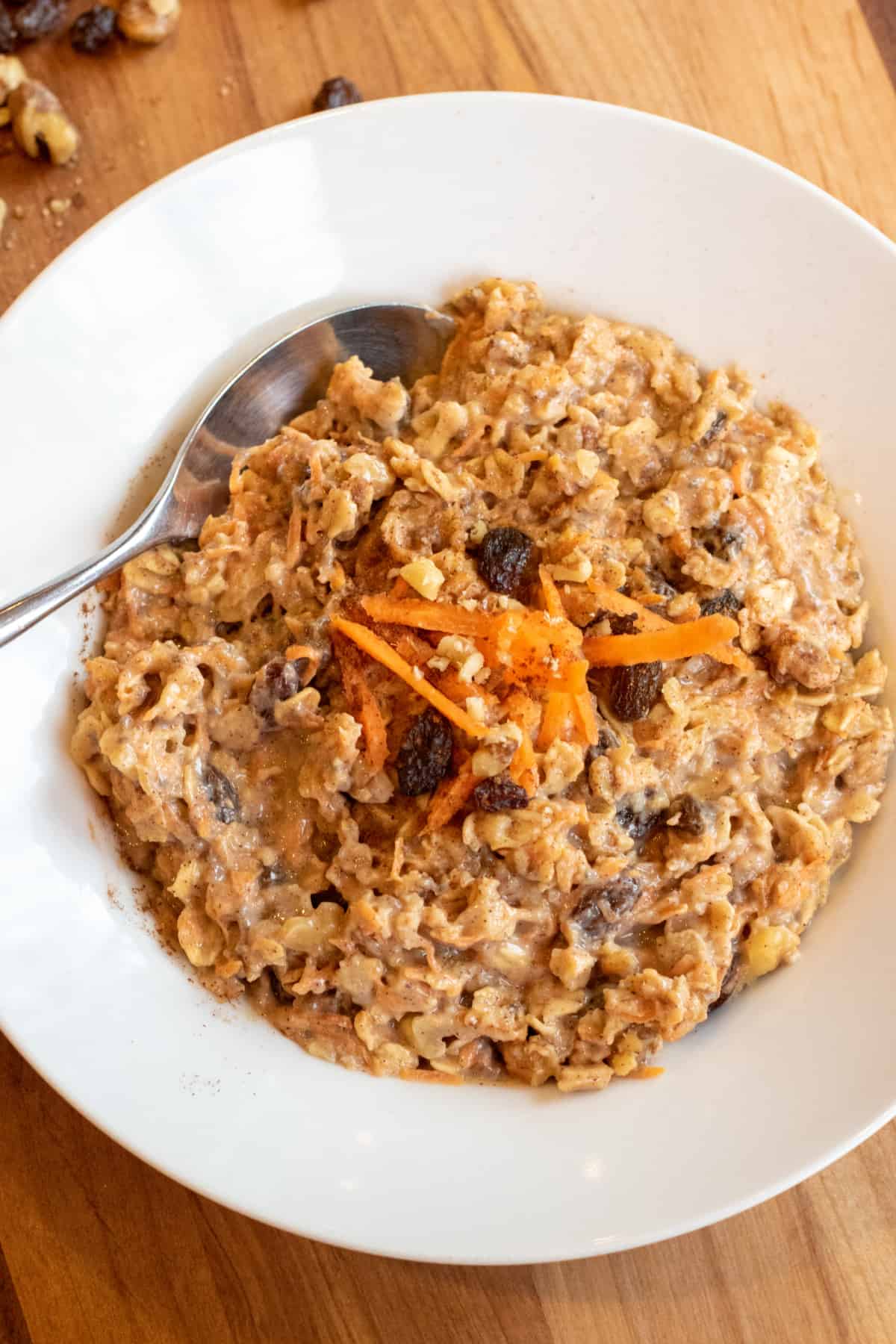 a bowl of carrot cake oatmeal with a spoon in it.