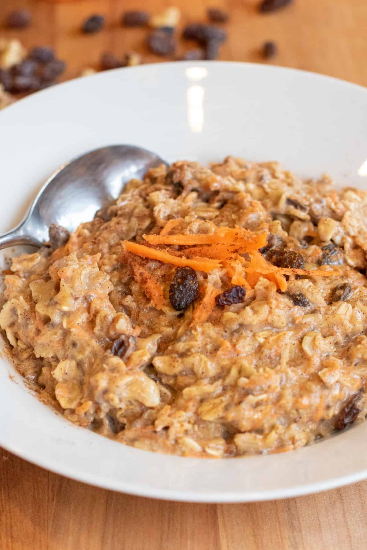 a bowl of carrot cake oatmeal with a spoon in it.