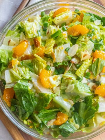 an overhead shot of a bowl of romaine lettuce salad with mandarins and almonds.