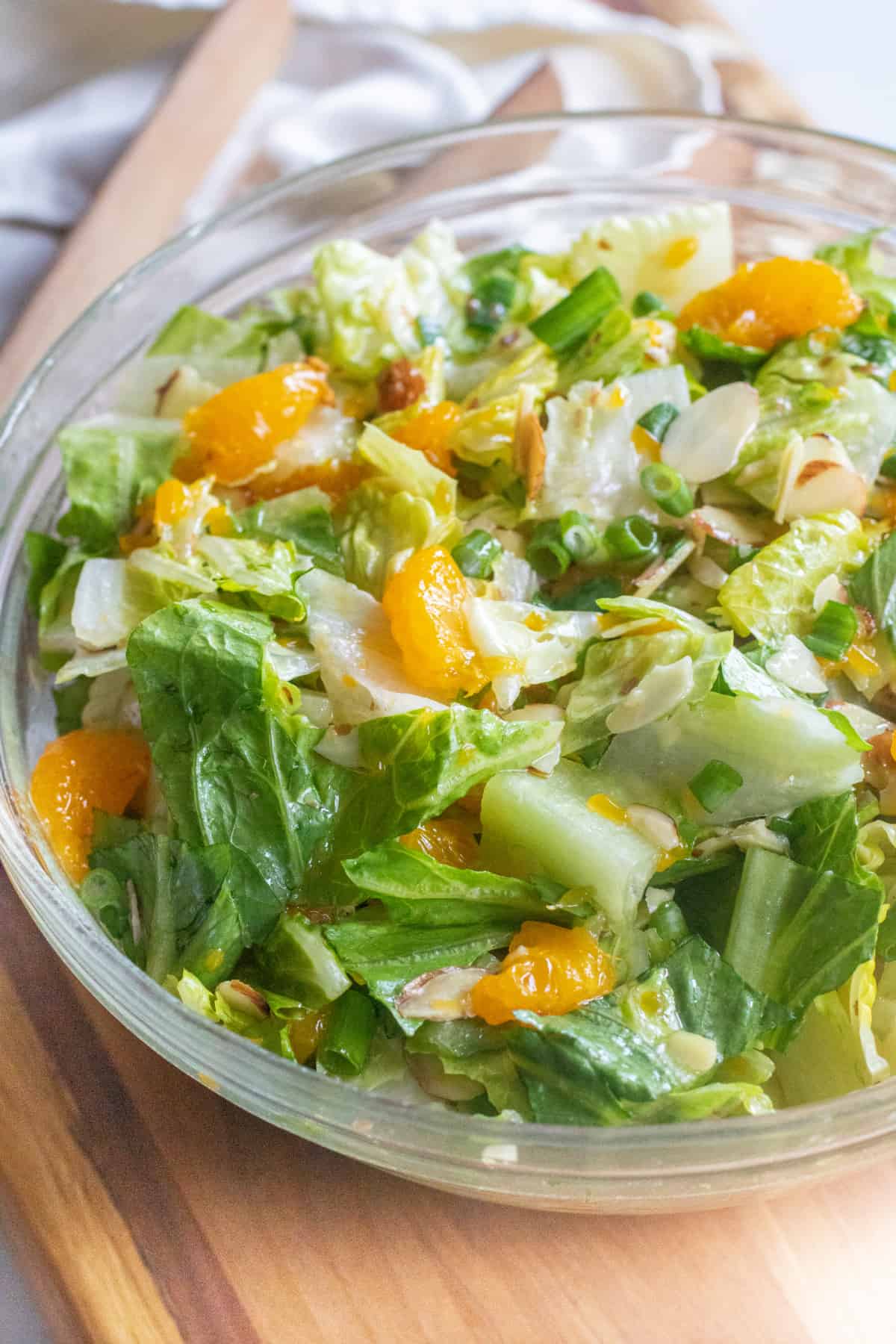 an overhead shot of a bowl of romaine lettuce salad with mandarins and almonds.