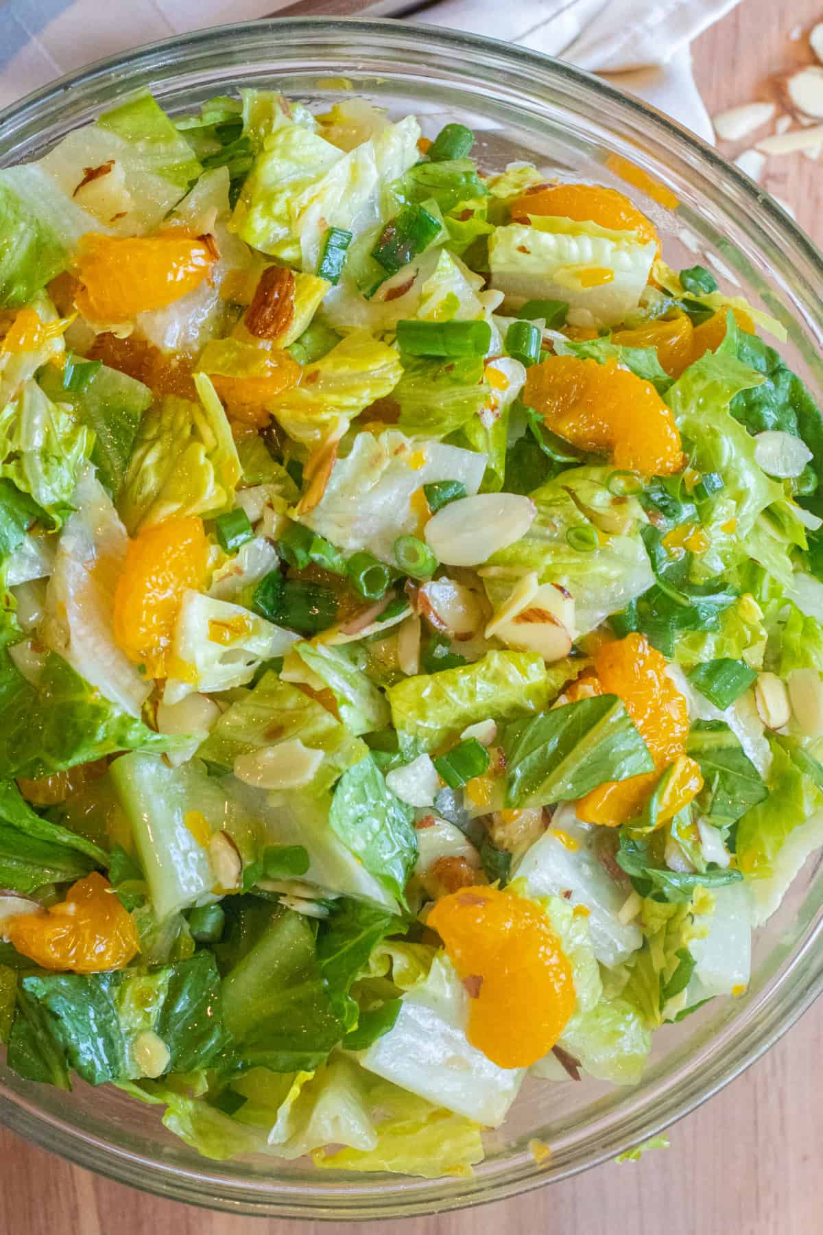 an overhead shot of a bowl of romaine lettuce salad with mandarins and almonds.
