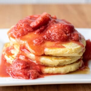 a stack of pancakes with strawberry compote on top.