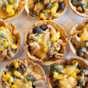 an overhead of taco cups with melted cheese on a plate.