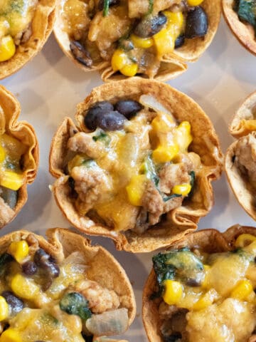 an overhead of taco cups with melted cheese on a plate.