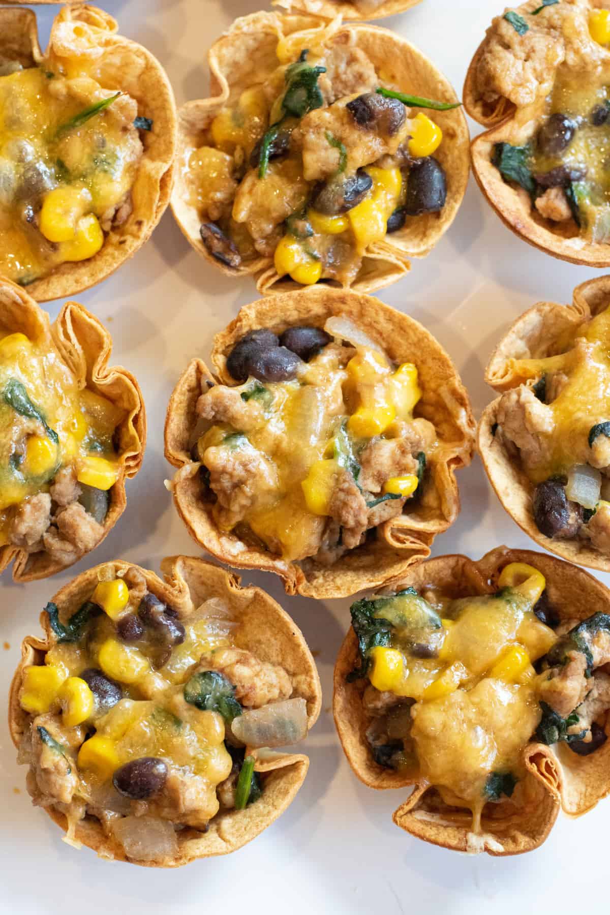 an overhead of taco cups with melted cheese on a plate.