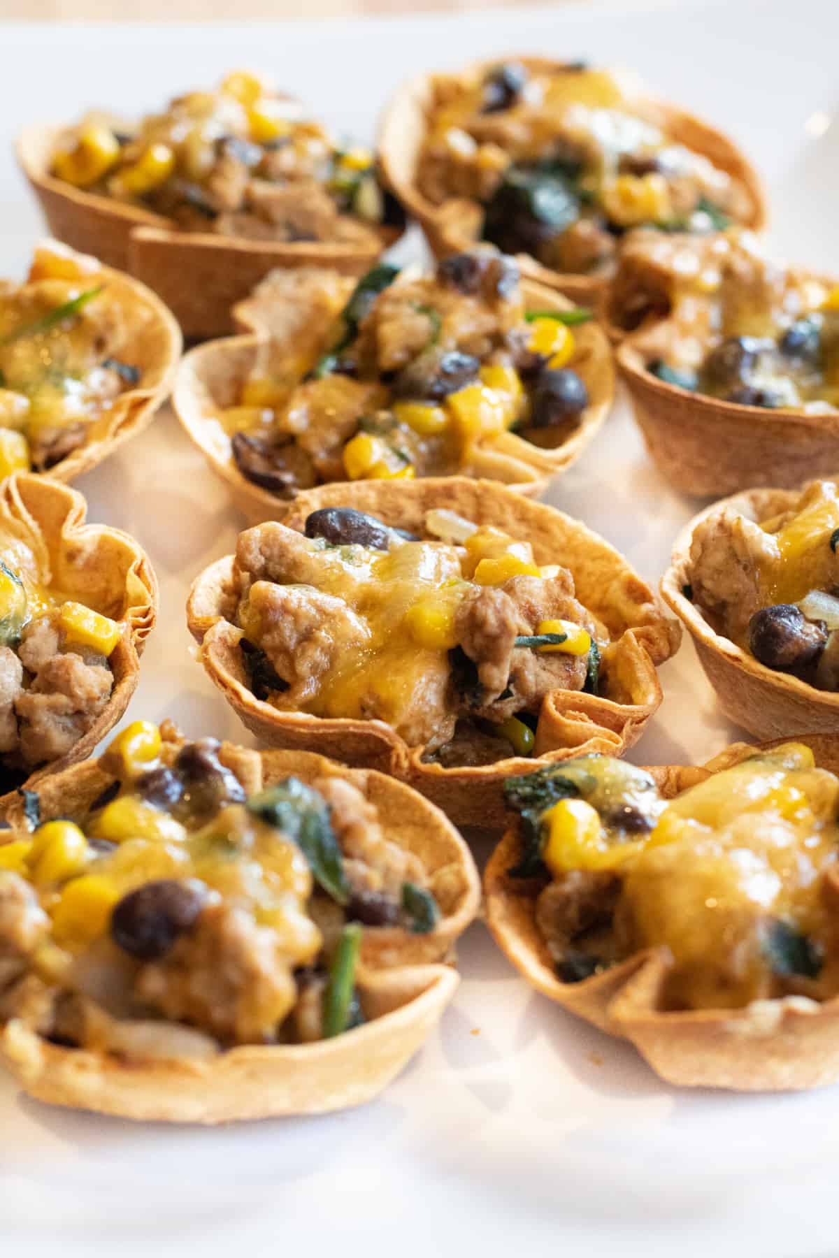 an overhead of taco cups with melted cheese on a plate.