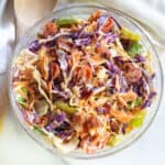 a bowl of coleslaw with bacon tomatoes and some lettuce.