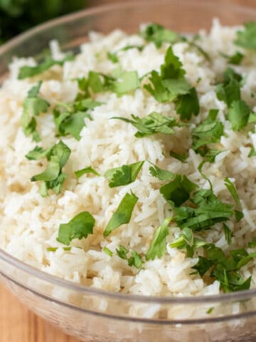 a bowl of rice topped with chopped cilantro.