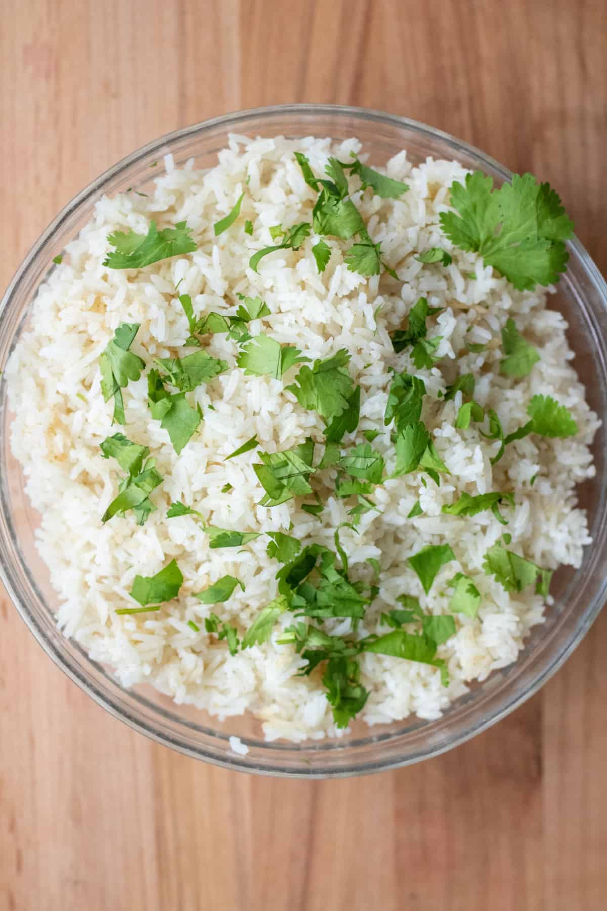 an overhead of a bowl of rice topped with fresh cilantro.