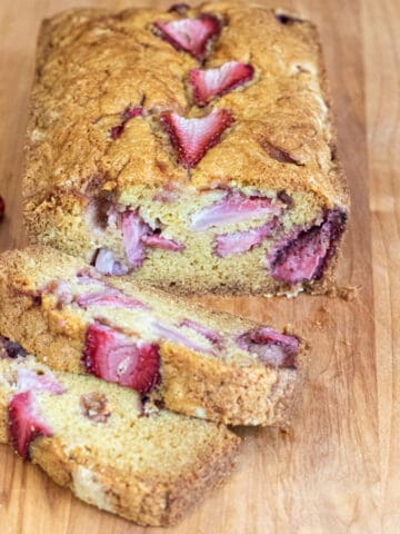 a loaf of bread with strawberries and slices.